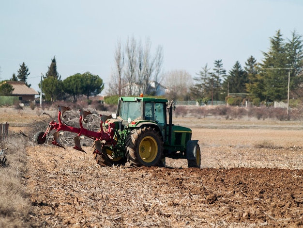 Foto traktor auf dem feld gegen klaren himmel