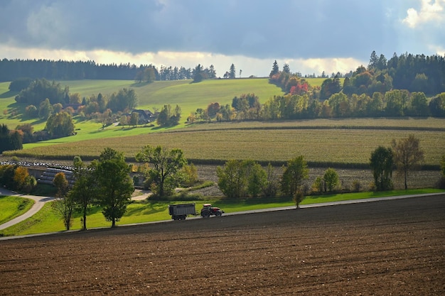 Traktor auf dem Feld Schöne Herbstnatur mit Landschaft in der Tschechischen Republik Bunte Bäume.