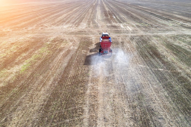 Traktor, der Kunstdünger auf dem Feld verbreitet