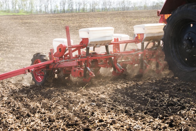 Traktor in einem Feld der schwarzen Erde mit einem gezogenen Saatgutbohrer