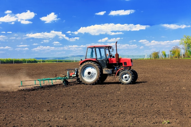 Traktor pflügt die Felder im zeitigen Frühjahr.