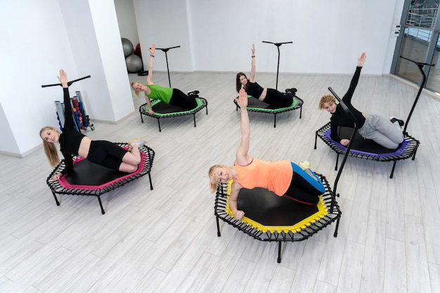 El trampolín para las niñas de fitness se dedican a un físico de rebote lindo y musculoso profesional