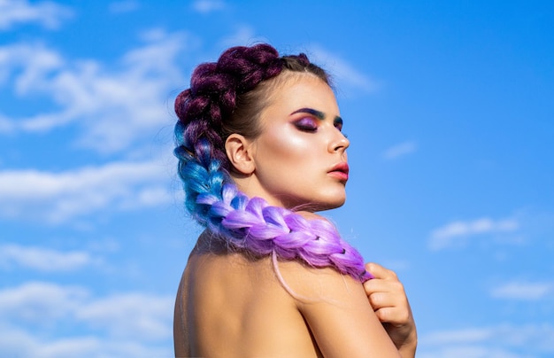 Tranças de menina no céu de fundo Maquiagem brilhante Tranças cor de rosa Penteado de rabo de cavalo Menina com kanekalon colorido trançado no cabelo Mulher bonita cabelo ombre violeta colorido e maquiagem profissional