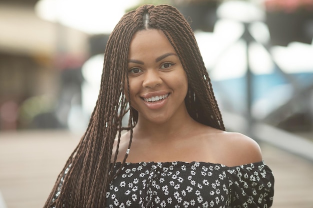 Tranças. Retrato de uma bela jovem afro-americana com penteado de tranças sorrindo.