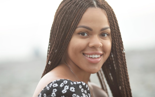 Tranças. Retrato de uma bela jovem afro-americana com penteado de tranças sorrindo.