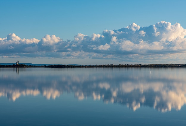 tranquila laguna, nubes y una iglesia en la distancia