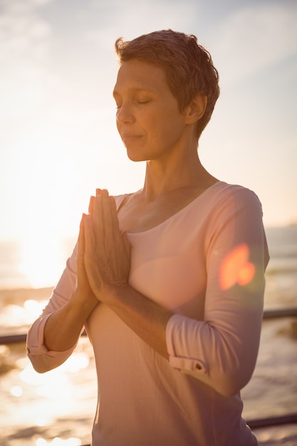 Tranquila mujer deportiva meditando en el paseo