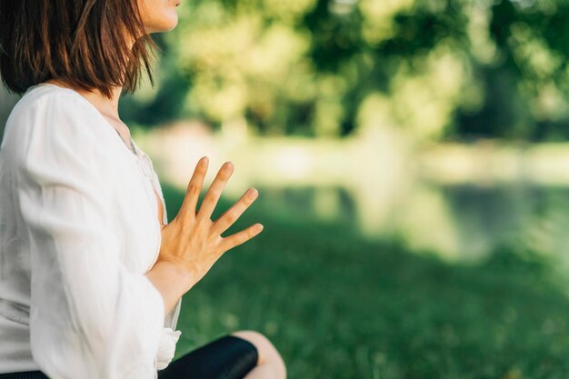 Tranquilidad Mujeres jóvenes pacíficas sentadas en posición de loto meditando junto al agua