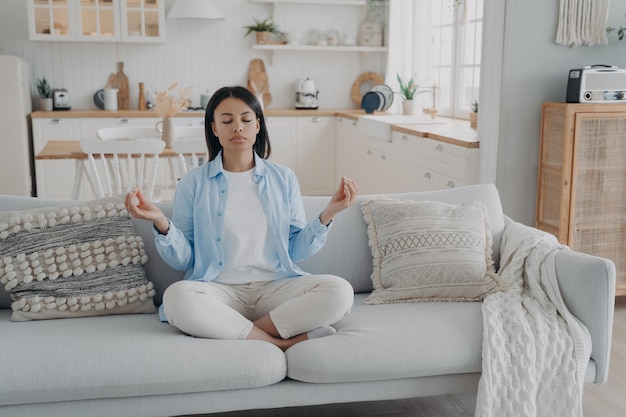 Tranquilidad zen y control de la respiración La mujer española está practicando gimnasia de yoga en el salón