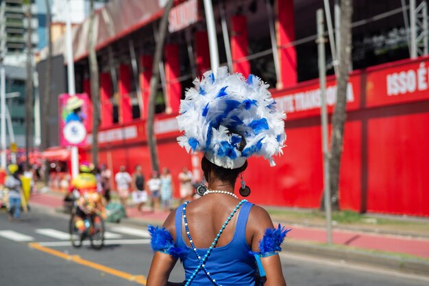 Foto los transeúntes vestidos con disfraces se ven durante la actuación de fuzue antes del carnaval en la ciudad de salvador, brasil