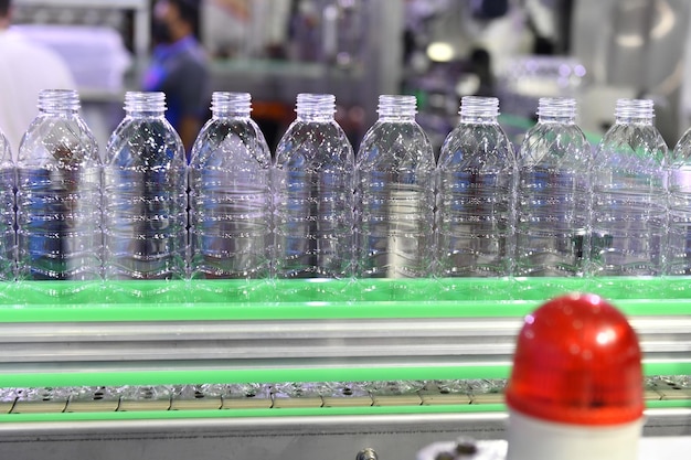 Foto transferencia de botellas de plástico transparente en sistemas de transporte automatizado industrial