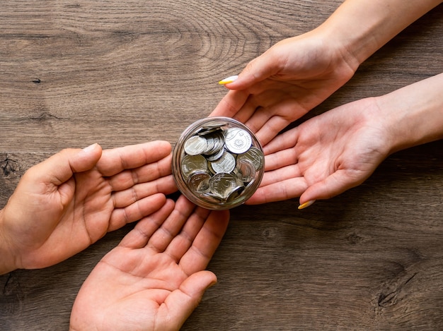 Transferência da lata com moedas de metal de homem para mulher