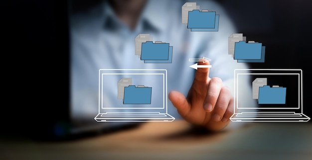 Foto transferindo arquivos entre laptops em uma tela virtual