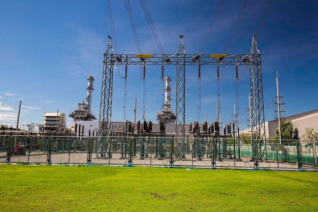 Foto transformador de alta tensión de columna contra el campo verde subestación de redistribución de corriente eléctrica