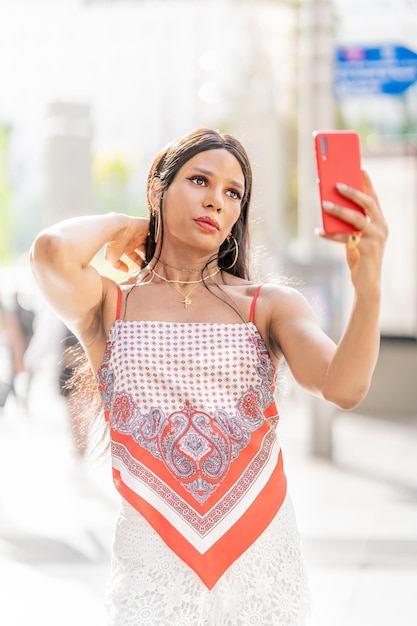 Transfrau, die ein Selfie macht, während sie im Freien sinnlich posiert