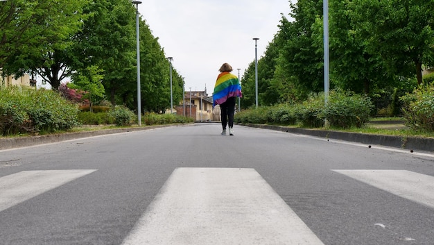 Transgênero feminino lésbico bissexual anda com bandeira lgbt na estrada em um dia e celebra bissexuali