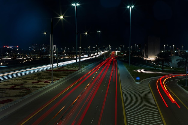 Trânsito rodoviário com luzes brancas e vermelhas à noite em Abu Dhabi Trânsito e vida noturna