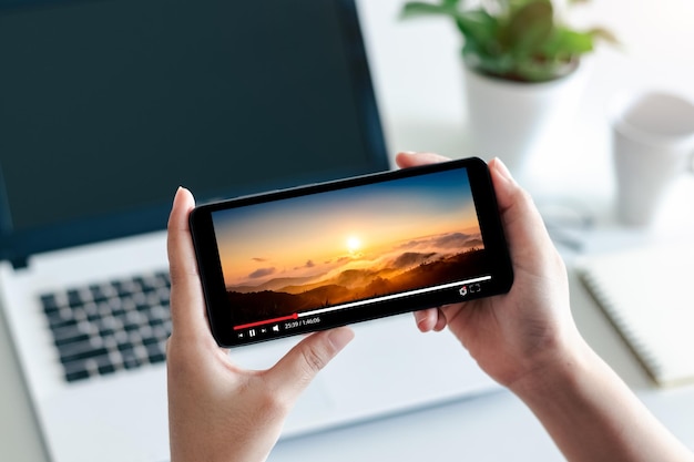 transmisión de películas en línea con teléfono inteligente Joven viendo películas en teléfono móvil con servicio de reproductor de video imaginario