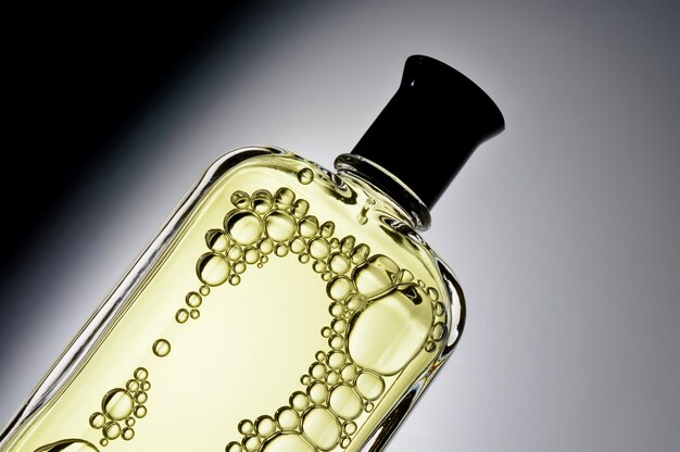 Transparente Gläser mit Parfüm liegen auf hellem Hintergrund Nahaufnahme