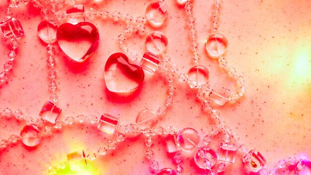 Transparente Herzen und Perlen auf Marmor in rosa Ton perfekte Valentinstagsgrußkarte