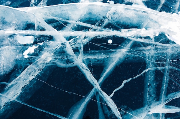 Transparente hielo azul agrietado en el lago Baikal en invierno. Hermoso fondo de naturaleza de invierno. Baikal, Siberia, Rusia.