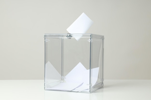 Transparente Schachtel und Stimmzettel auf grauem Hintergrund