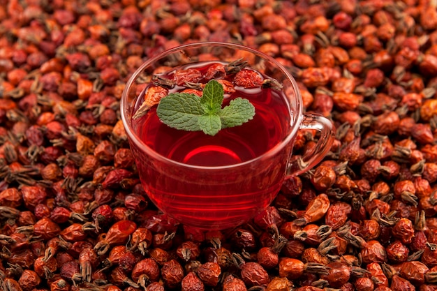 Transparente Tasse Kräutertee aus Hibiskus und getrockneter Hagebutte