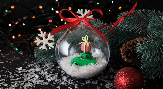 Transparenter Weihnachtsball mit Spielzeugauto und Geschenk