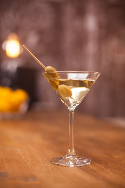 Transparentes Glas gefüllt mit trockenem weißen Martini auf einer Theke. Raffinierter Schnaps. Frisches Getränk.