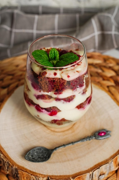 Transparentes Glas mit Schichtdessert Schokoladenkuchen und Schlagsahnebeeren