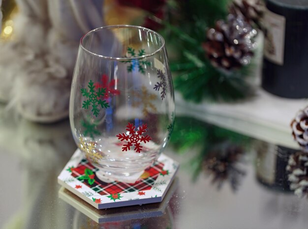 Foto transparentes glas mit weihnachts-schneeflocken-glittermustern elegantes neujahrs-familientisch und festliches dekor tischgestaltung für ein weihnachtsessen mit klarem leeren glas