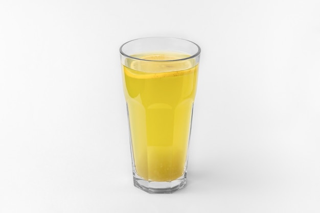 Transparentes Glas pastellgrüner Farbe, erfrischendes Sommer- oder Wintergetränk mit geschnittener Orange einzeln auf weißem und grauem Hintergrund mit natürlichem Schatten