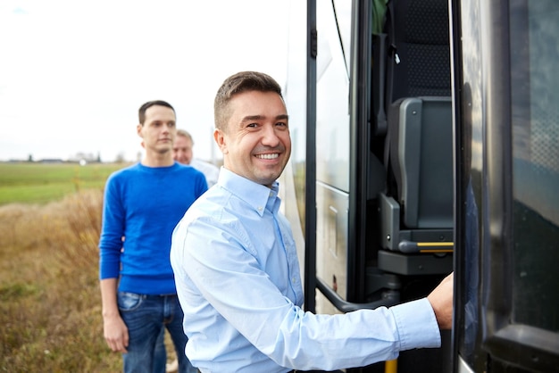 transport-, tourismus-, roadtrip- und personenkonzept - gruppe glücklicher männlicher passagiere, die in den reisebus einsteigen