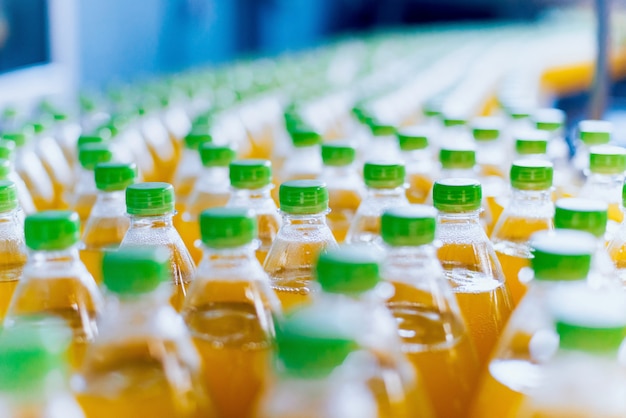 Transportador con botellas para jugo o agua. Equipos de fabrica de bebidas