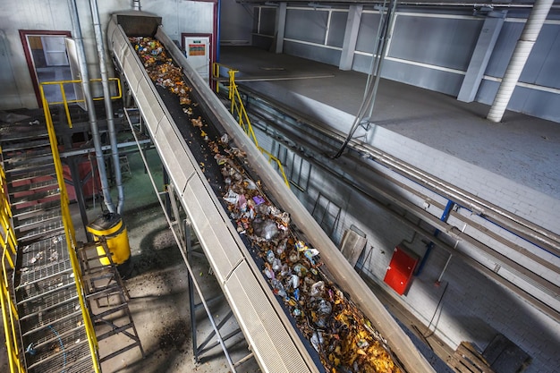 Transportador transportador en movimiento en la moderna planta de procesamiento de reciclaje de residuos Separación y clasificación de la recolección de basura Reciclaje y almacenamiento de residuos para su posterior eliminación