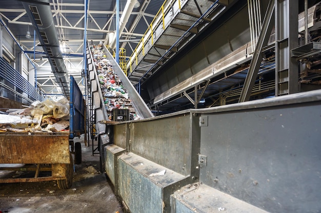 Transportador transportador en movimiento en la moderna planta de procesamiento de reciclaje de residuos Separación y clasificación de la recolección de basura Reciclaje y almacenamiento de residuos para su posterior eliminación