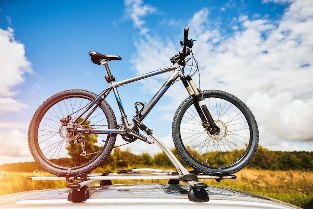 Transporte de bicicletas Bicicletas en el techo de un automóvil contra un hermoso cielo Transporte y logística de grandes cargas y viajes en automóvil Actividades de vacaciones de verano