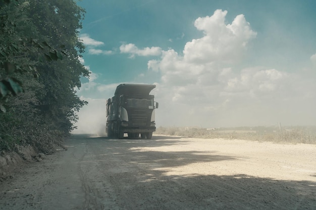 Transporte de camiones volquete industriales de paseos en piedras en un camino polvoriento Trabajo de carrera