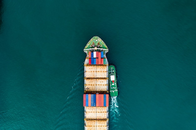 Transporte de contenedores de carga de envío en la vista aérea del mar verde