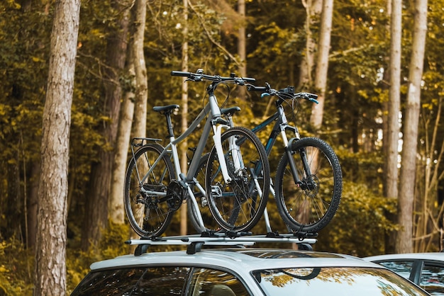 Foto transporte de bicicletas no teto do carro para uma aventura de verão explorando a estrada aberta transporte de mountain bike e outros equipamentos no telhado