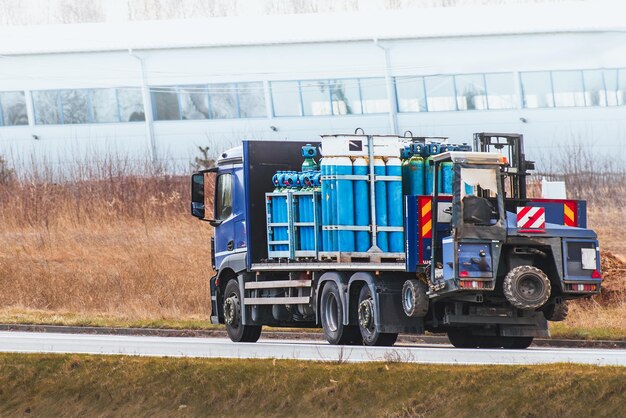 Foto transporte de cilindros de gás líquido para uso industrial caminhão de cilindro de gás azul em trânsito movimento seguro de recipientes de gás inflamável