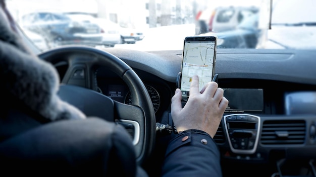 Transporte, destino, tecnologia moderna e conceito de pessoas - mão masculina procurando rota usando o sistema de navegação na tela móvel do carro
