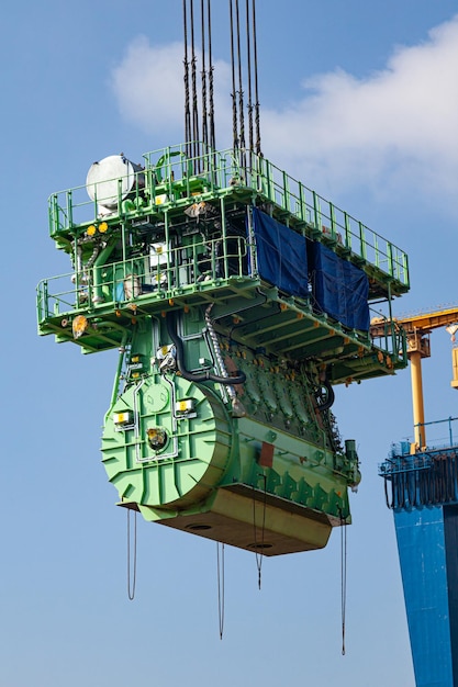 Transporte de un gran motor marino por una grúa portuaria utilizando cables de acero