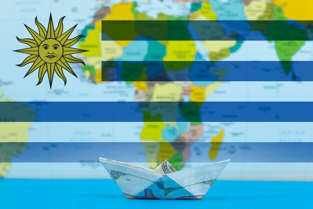 Transporte marítimo de Uruguay concepto de carga y logística idea barco de papel con bandera de Uruguay a granel