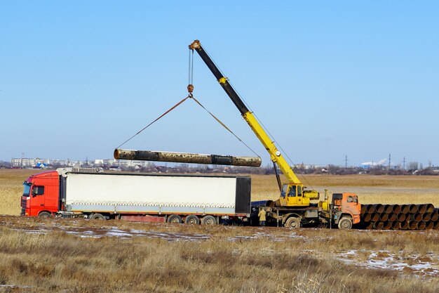 Transporte de mercancías por carretera en todo el mundo Cargando un camión con una grúa para tuberías Rusia