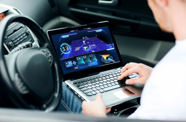 transporte, tecnologia moderna e conceito de pessoas - homem usando sistema de navegação no computador portátil no carro