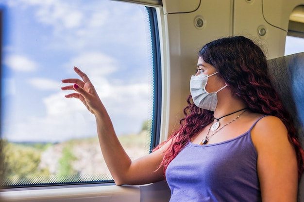 Transporte en tren viajero pasajero mirando con emoción a la ventana Joven turista latino venezolano