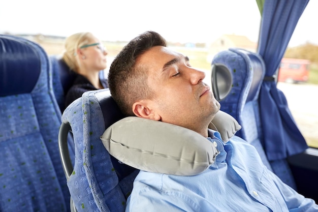 transporte, turismo, descanso, comodidad y concepto de personas - hombre durmiendo en autobús de viaje con almohada inflable de cuello cervical