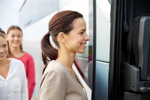 transporte, turismo, viaje por carretera y concepto de personas - grupo de pasajeras felices que abordan el autobús de viaje