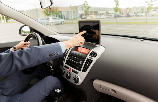 transporte, viagem de negócios, tecnologia, navegação e conceito de pessoas - close-up de jovem com computador tablet pc dirigindo carro